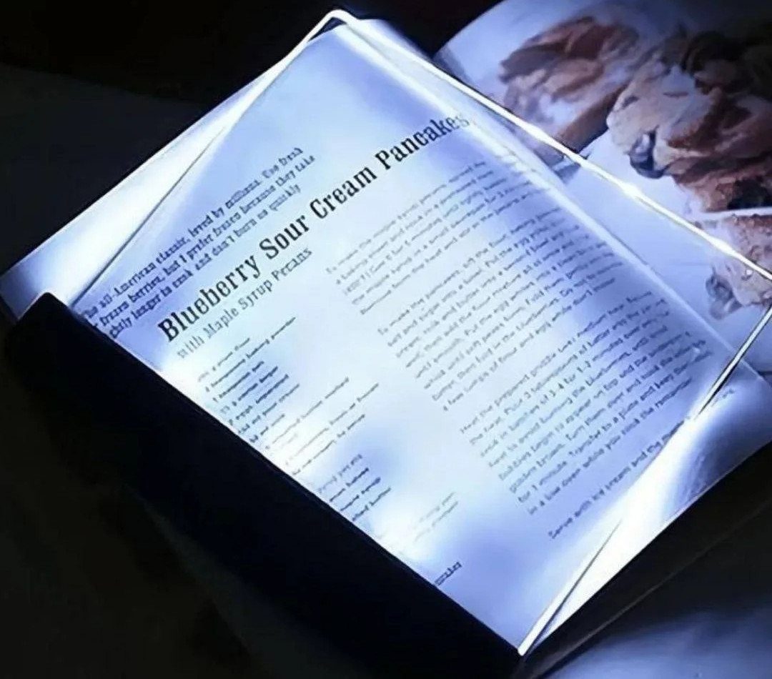 LED book light illuminating a pancake recipe in a cookbook in a dark room