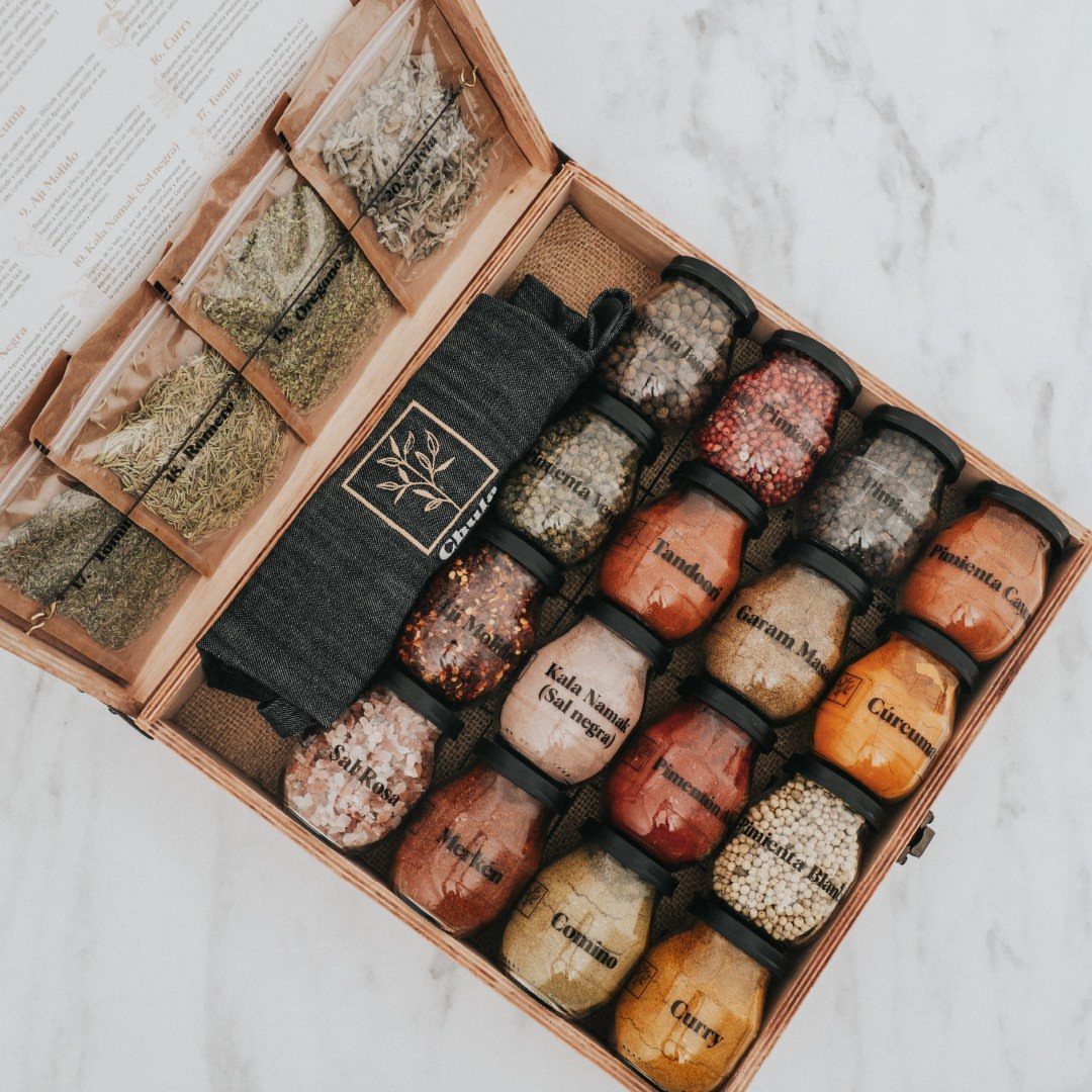 Wooden gift box filled with assorted gourmet spice jars and dried herb packets.