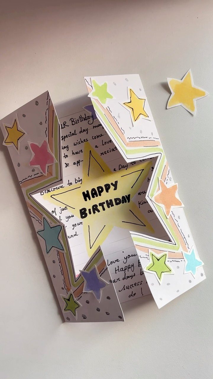 Handmade 3D pop-up birthday card with a large yellow star and colorful accents.