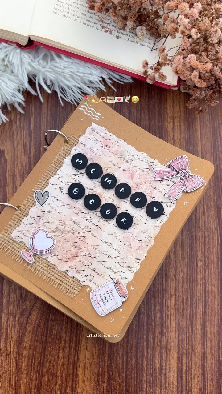 Handmade memory book with brown cover and decorative elements on a wooden table.