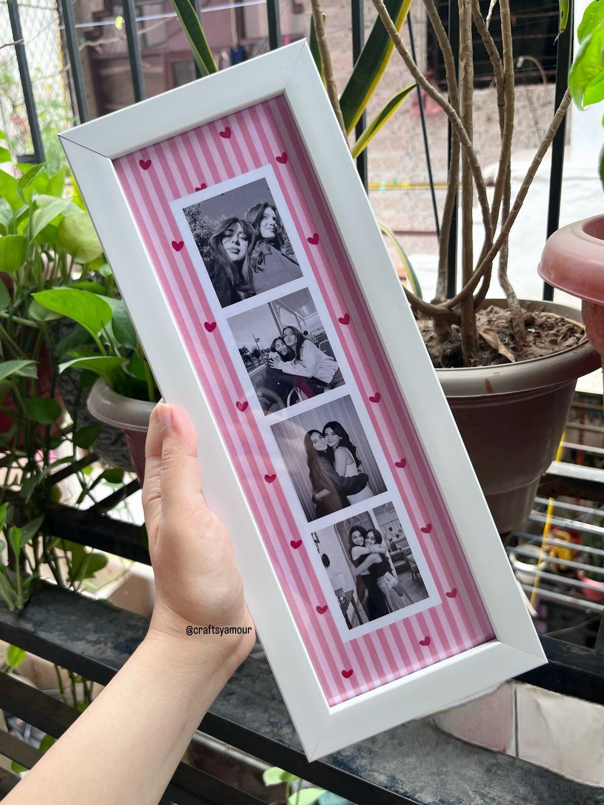 White picture frame with four photos of women on a pink striped background