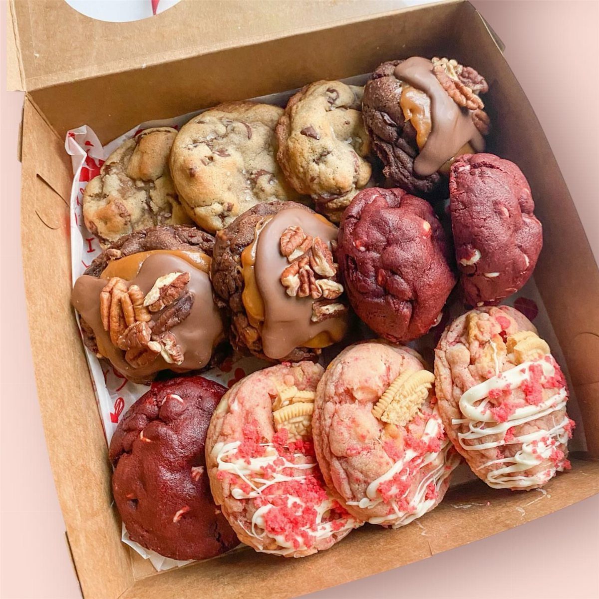 Assorted gourmet cookies with chocolate and pecans in a brown cardboard box