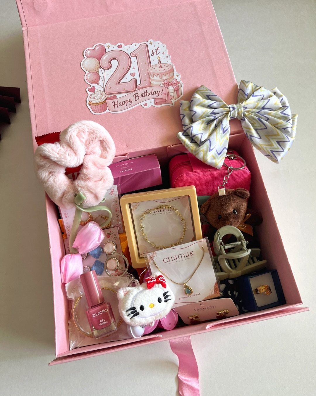 Pink gift box filled with jewelry, plushies, and accessories for a 21st birthday.