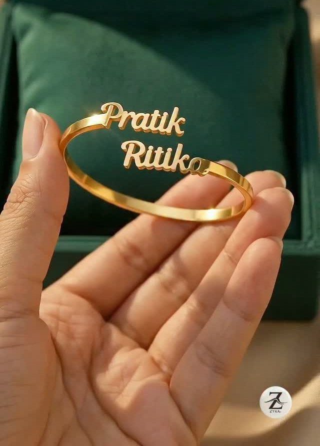 Gold personalized bracelet with names Pratik and Ritik held over a green box