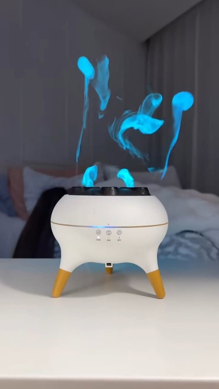 White anti-gravity humidifier with floating blue water droplets on a white table