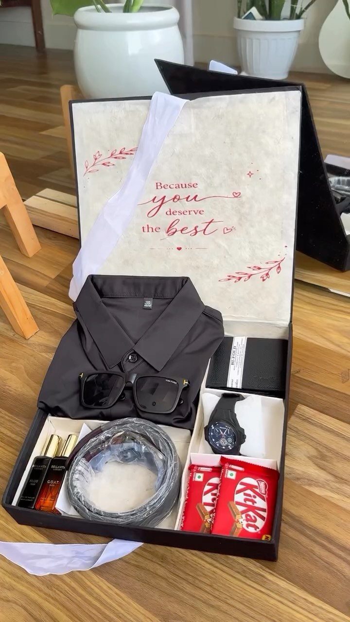 Gift box with black shirt, sunglasses, watch, perfume, and KitKat chocolates.