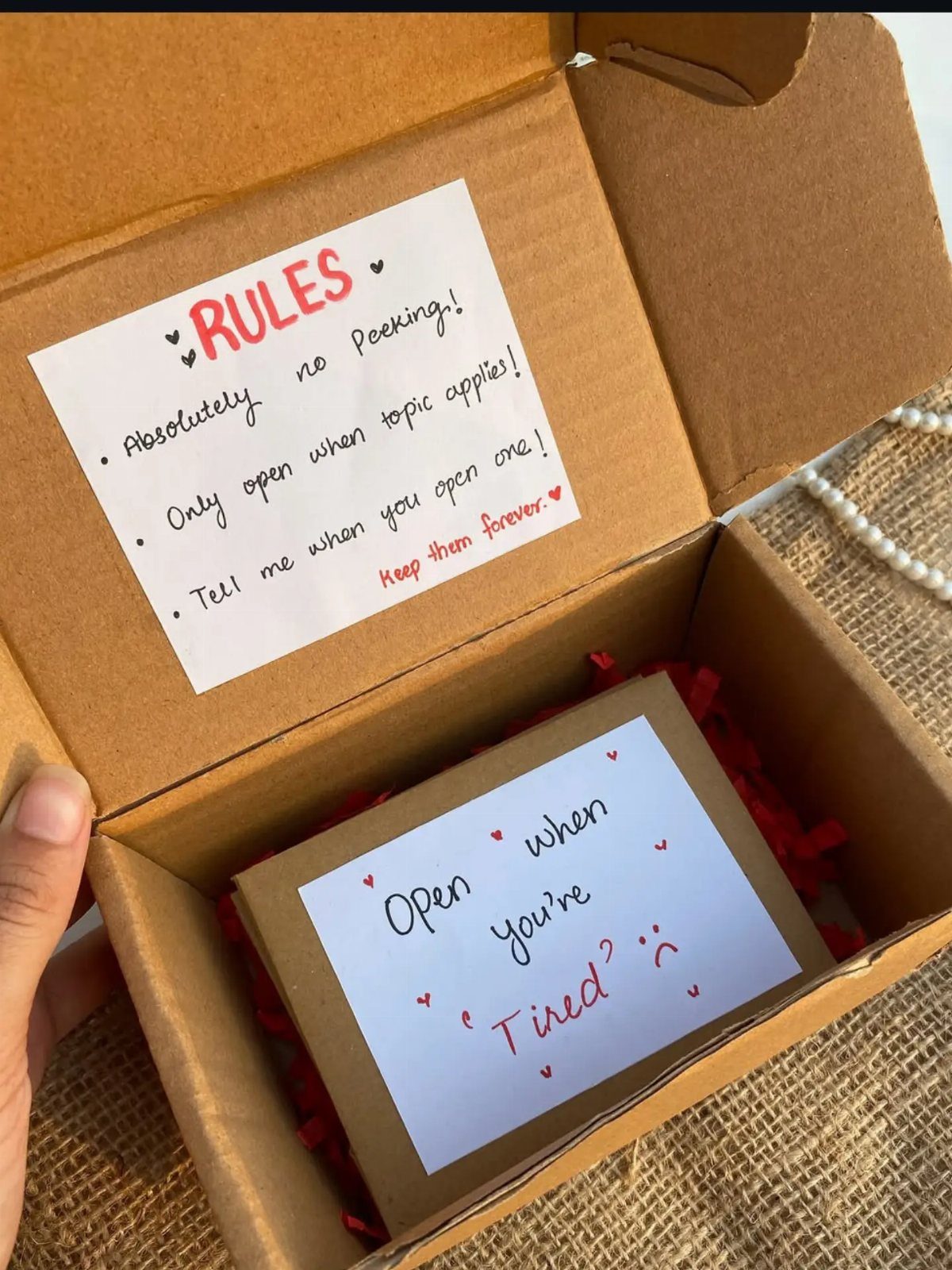 Handmade open when gift box with a rules note and red filler.