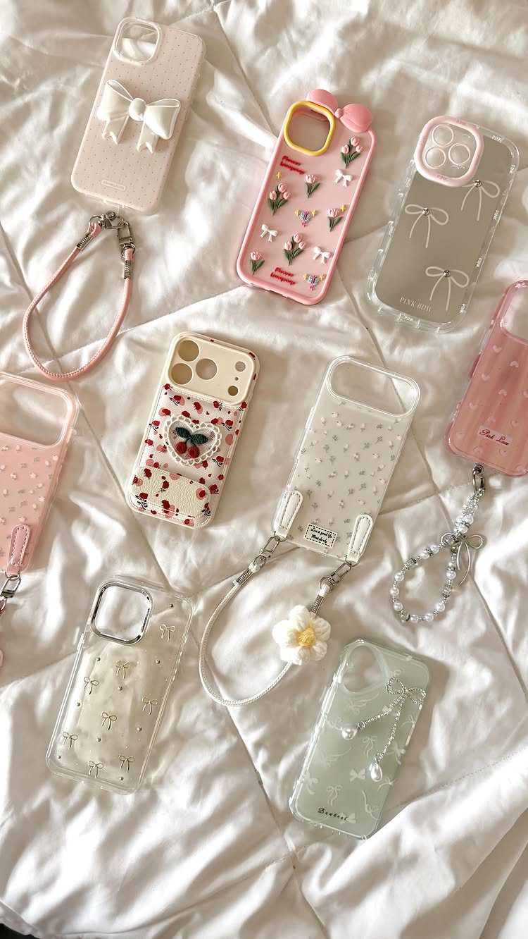 Decorative feminine smartphone cases with bows and flowers on a white fabric background