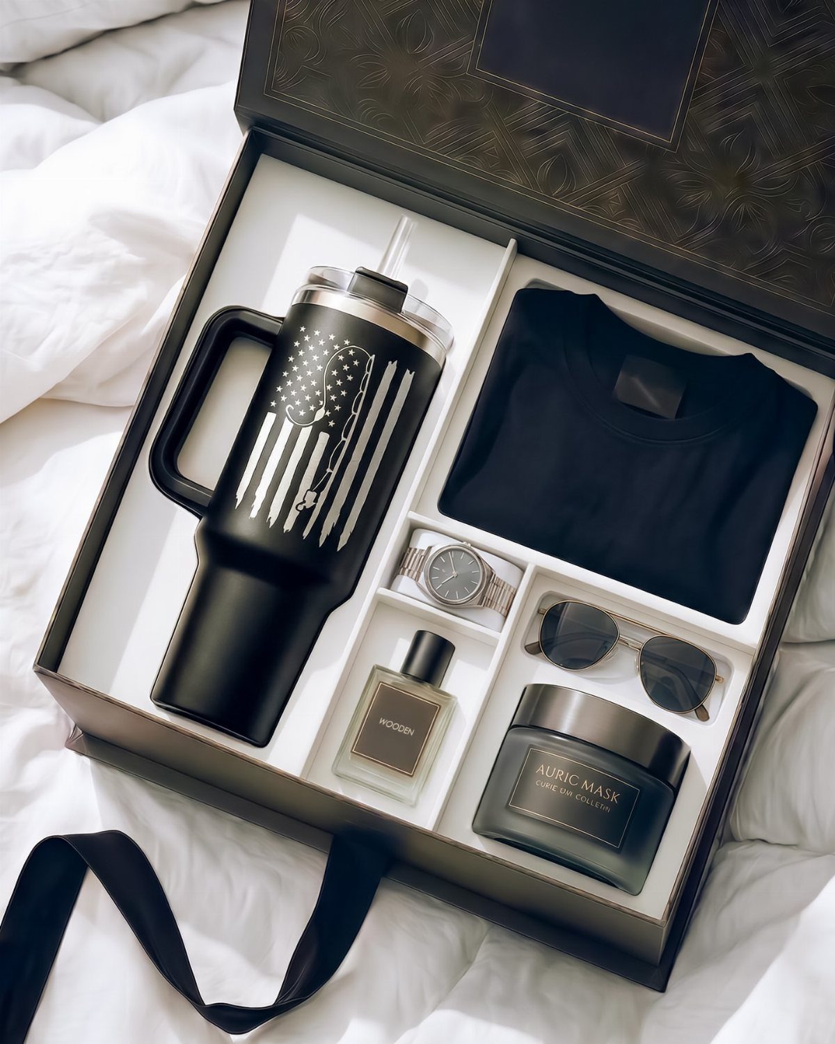 Black gift box with a flag-patterned tumbler, t-shirt, watch, and grooming products.
