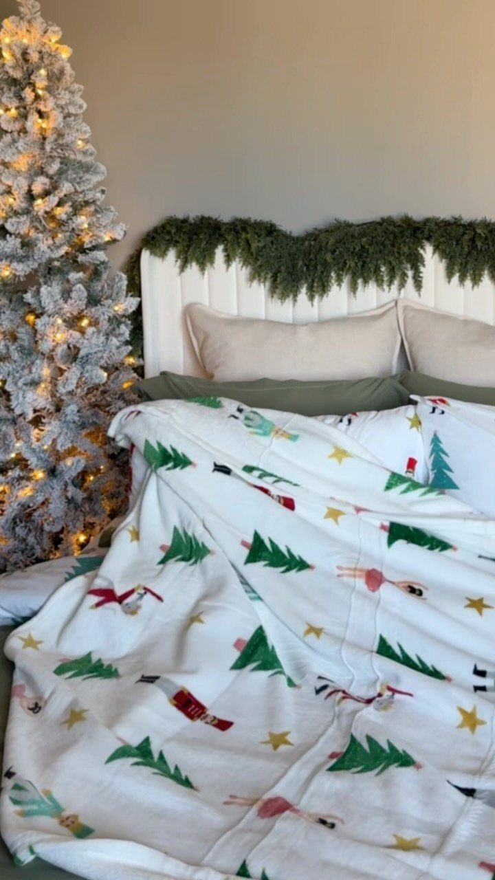 Festive white holiday blanket with Christmas tree patterns on a cozy bed