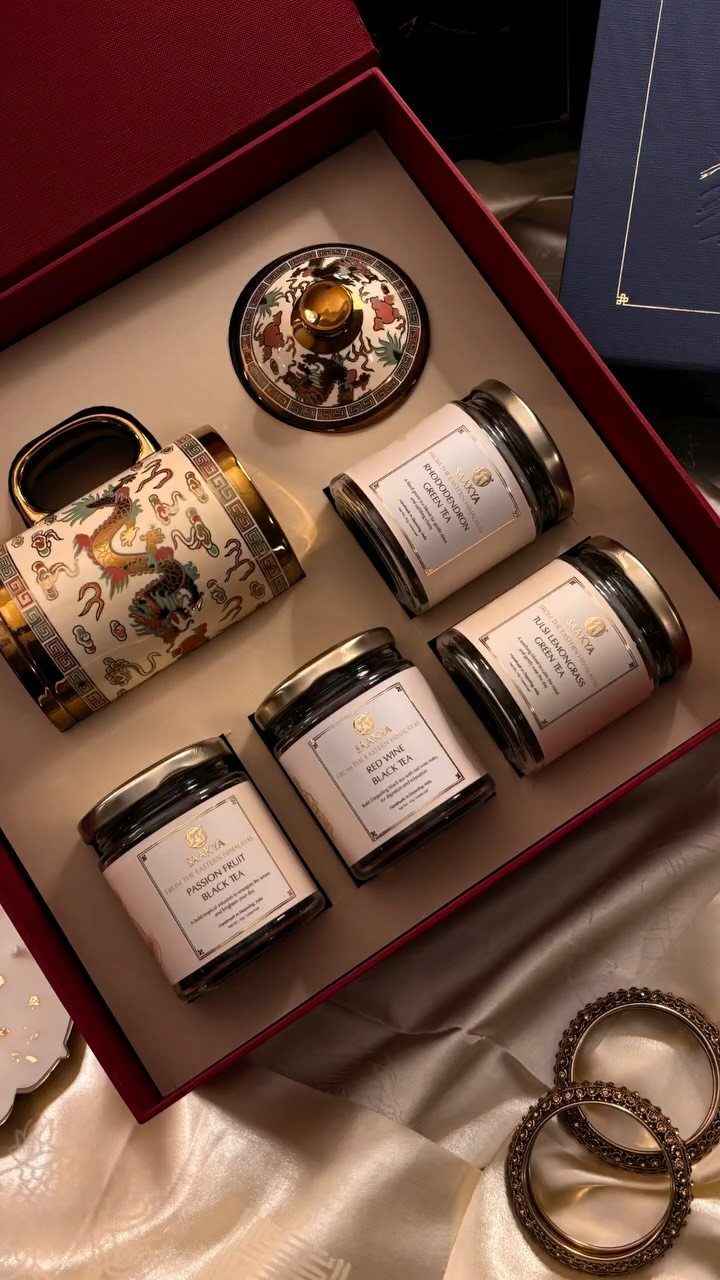 Tea gift set with a decorative mug and four jars of loose leaf tea.
