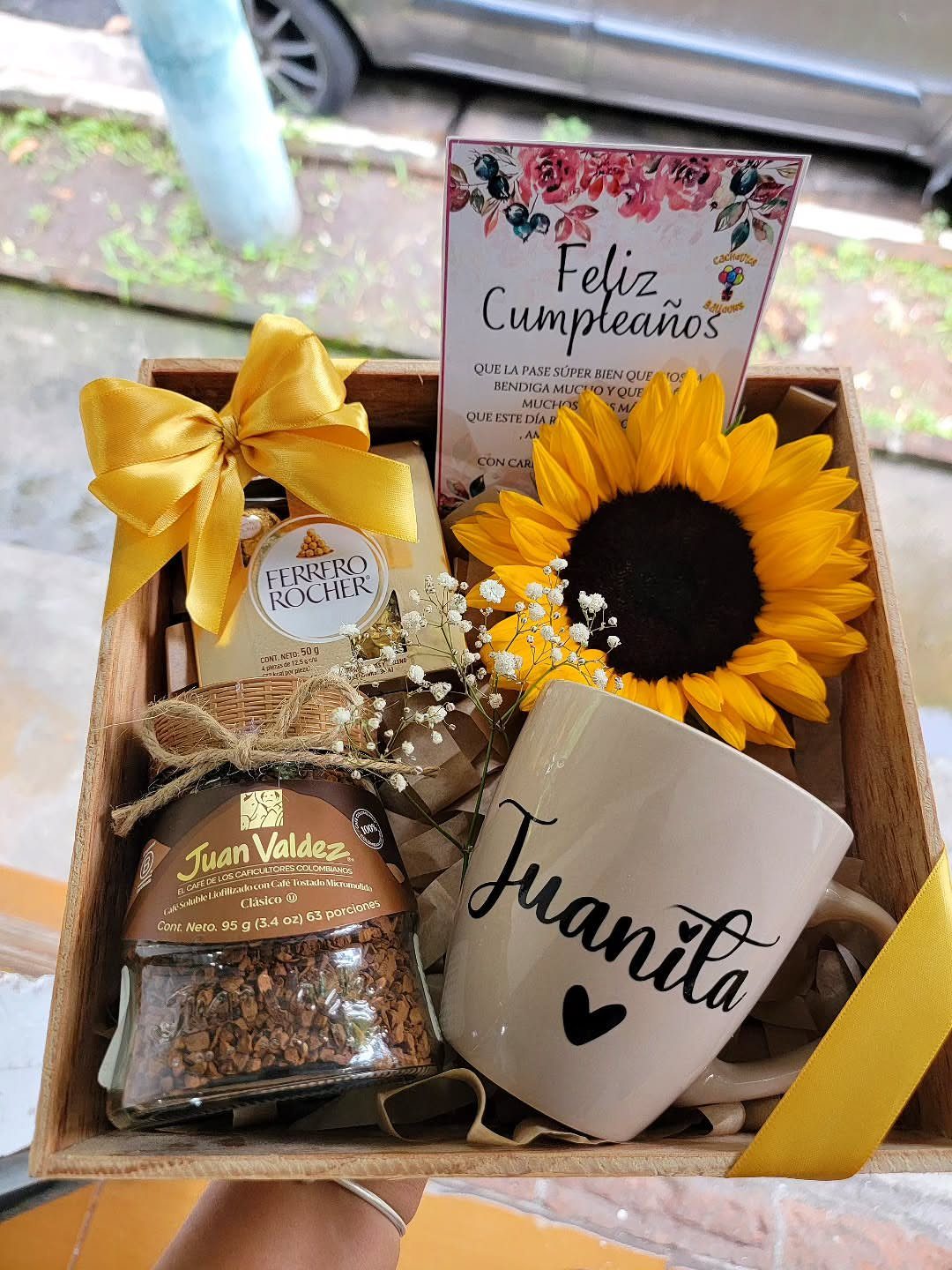 Wooden gift box with coffee, chocolates, a personalized mug, and a sunflower.