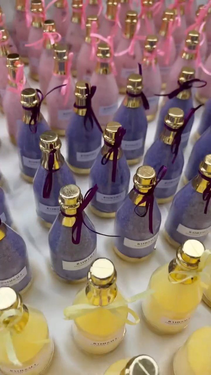 Small glass bottles filled with colorful bath salts tied with ribbons.