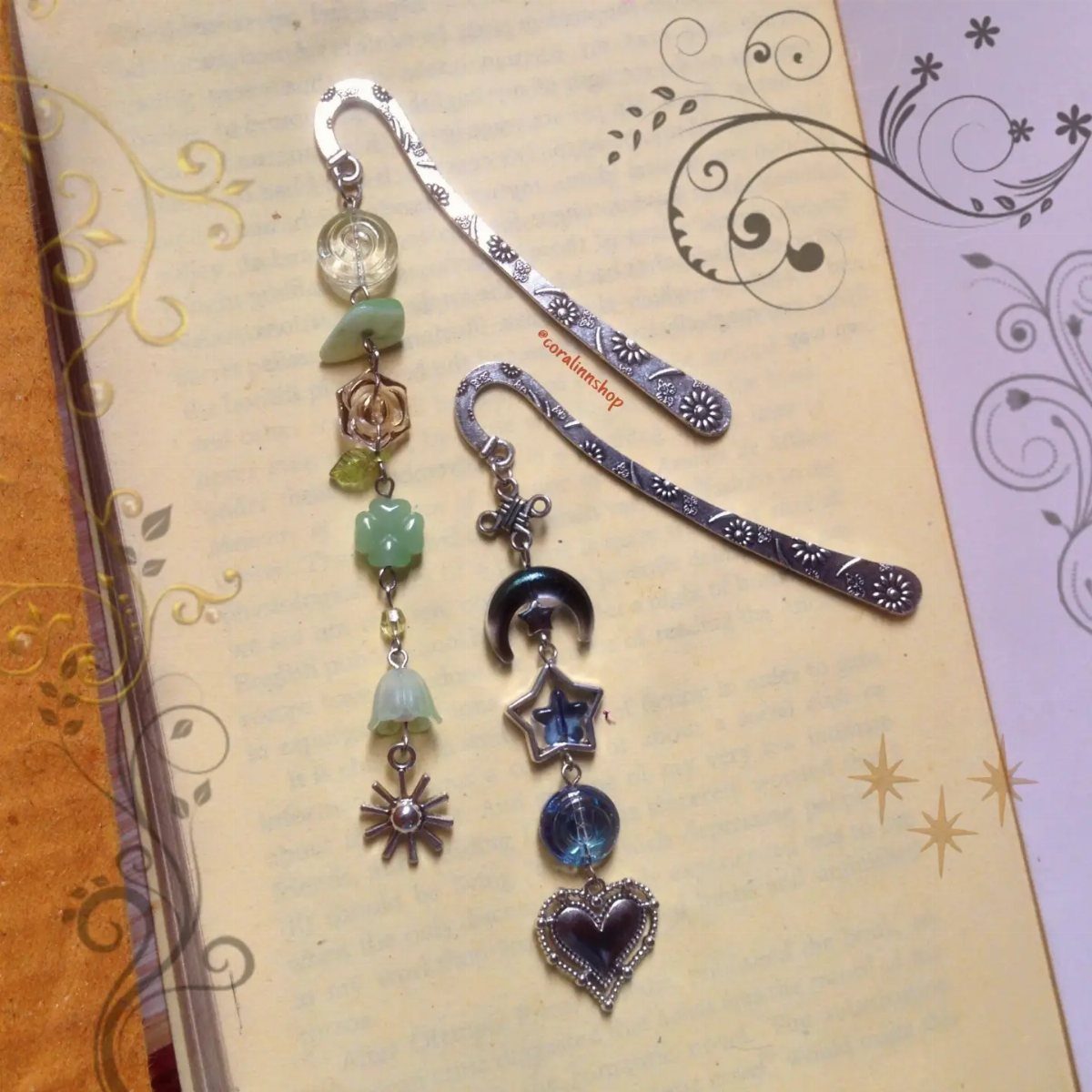 Silver metal bookmarks with decorative beads and charms on a floral page.