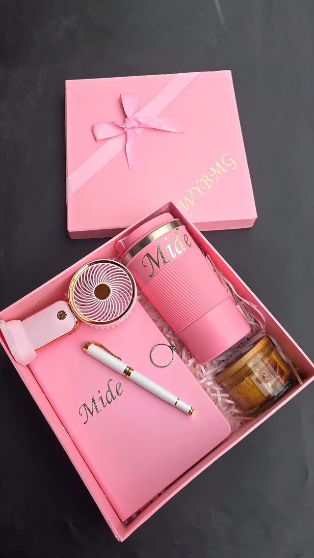 Pink gift box containing a personalized tumbler, notebook, pen, and small honey jar.