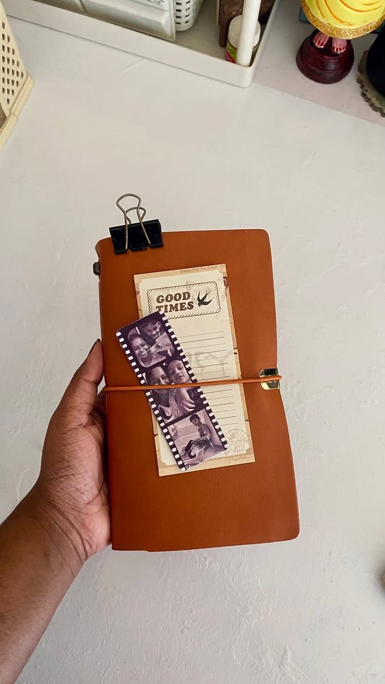 Brown leather notebook with vintage photos and a Good Times card attached.