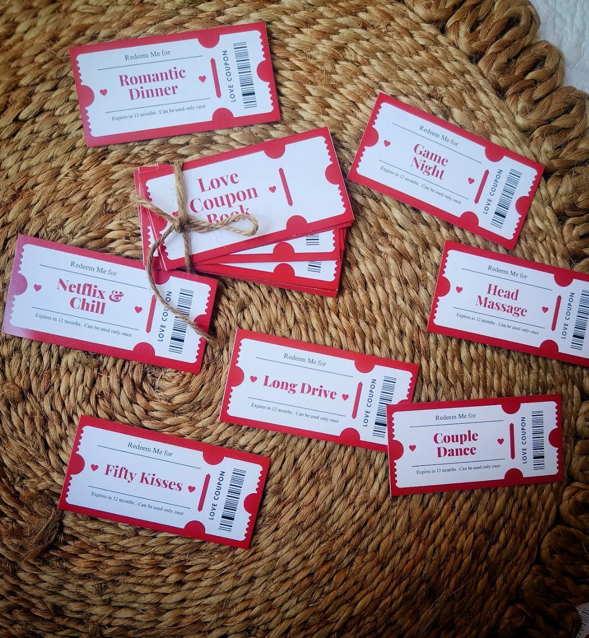 Red and white love coupon tickets scattered on a brown woven straw mat.