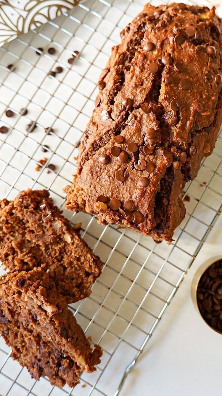 Chocolate chip banana bread loaf and slices on a metal cooling rack.