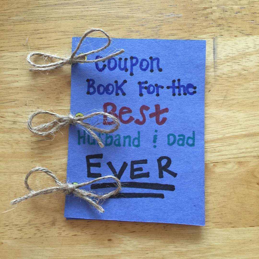 Handmade blue coupon book tied with twine bows on a wooden table.