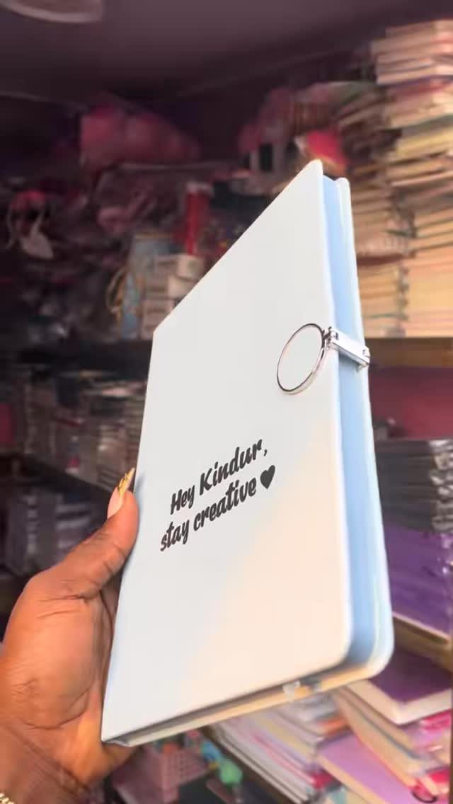 Light blue personalized journal with a silver ring and creative text on cover.