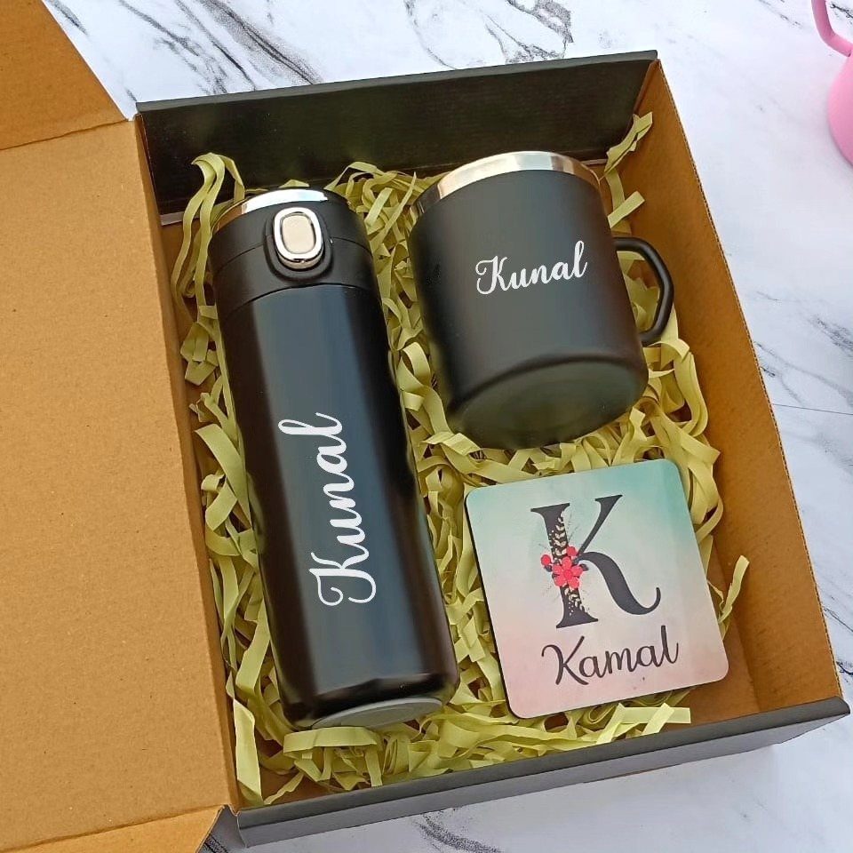 Personalized black water bottle and mug in a gift box with yellow filler.