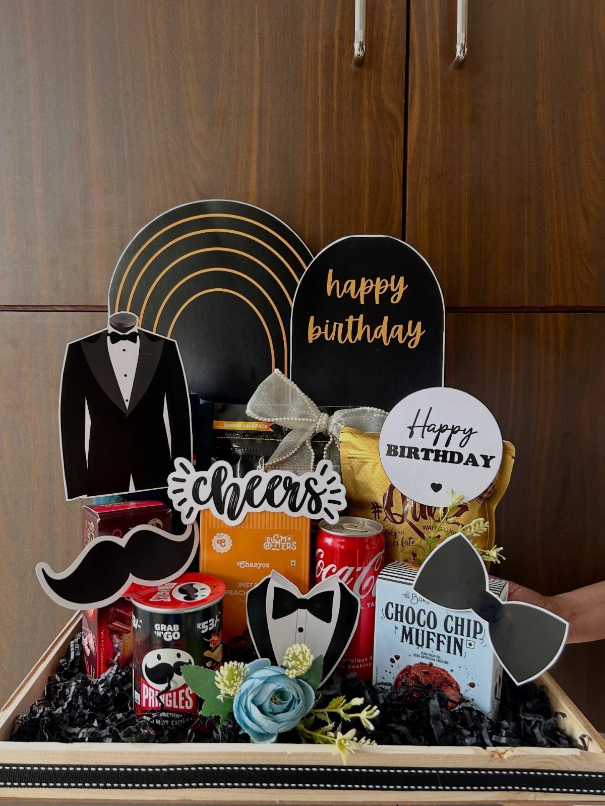 Birthday gift basket with snacks and black and gold tuxedo decorations for a man