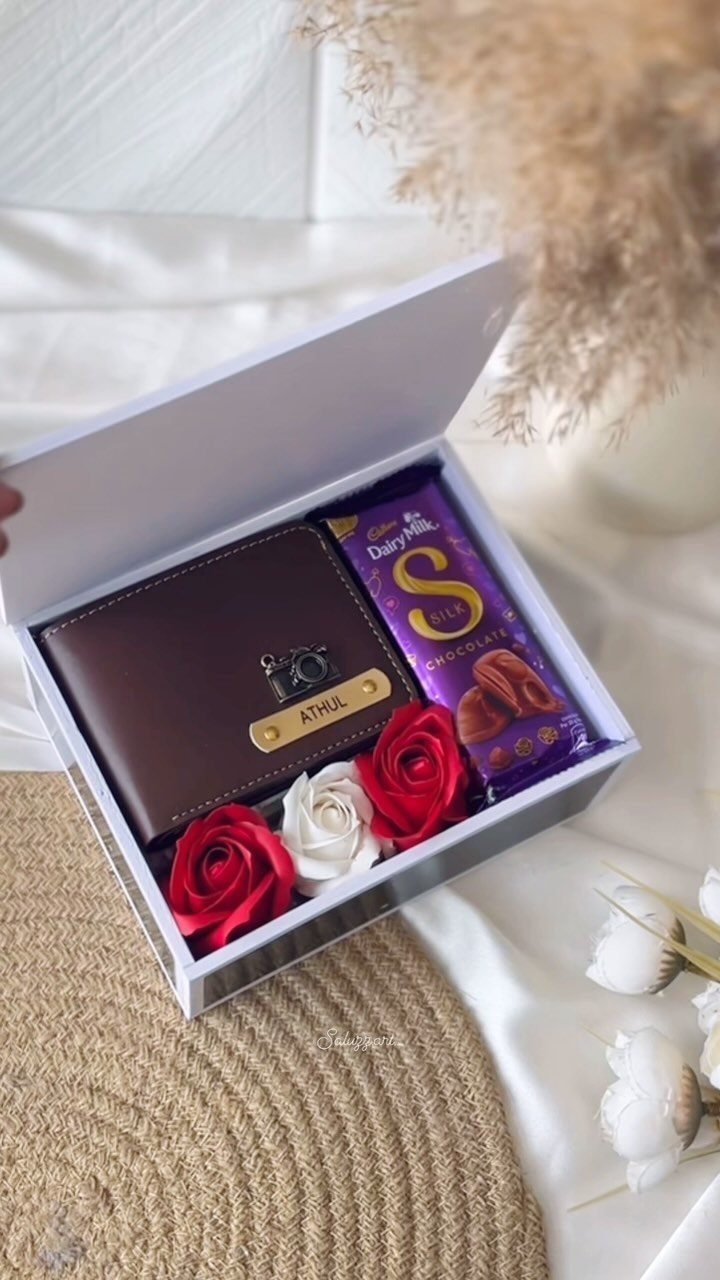 Brown leather wallet with name engraving, chocolate bar, and roses in a gift box