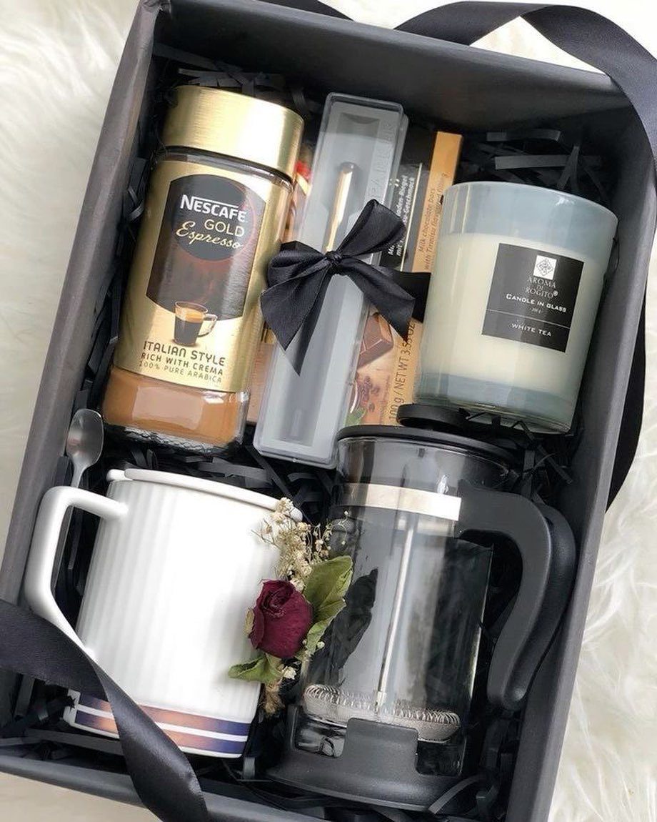 Coffee gift set with espresso jar, French press, white mug, and scented candle.
