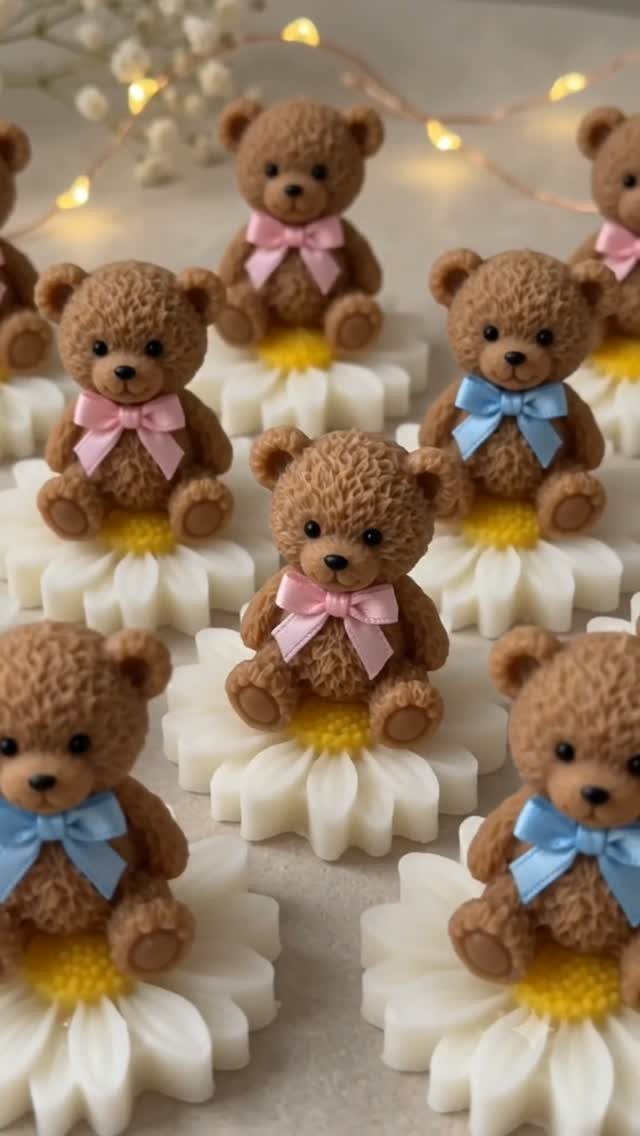 Small brown teddy bear figurines sitting on white daisy bases with colorful bows.