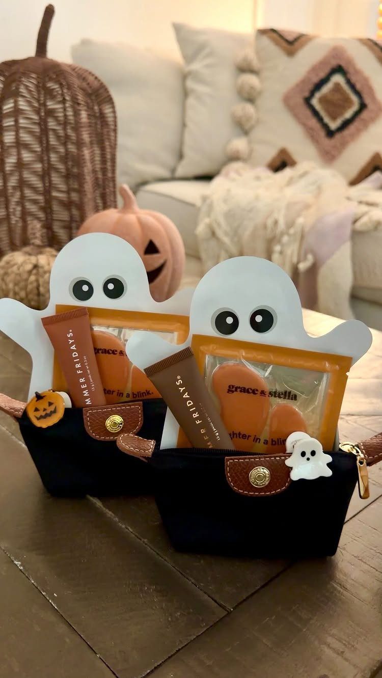Two ghost-themed gift pouches with skincare products on a wooden table.