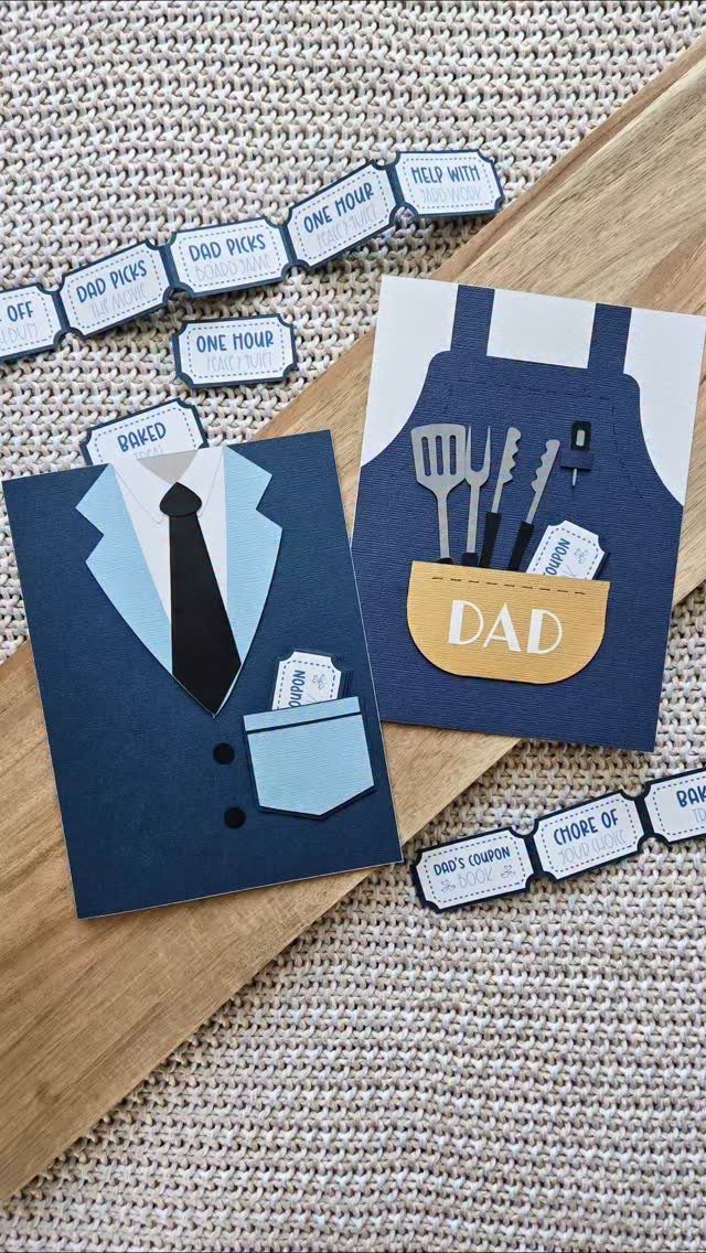 Handmade Father's Day cards and small paper coupons on a wooden surface.