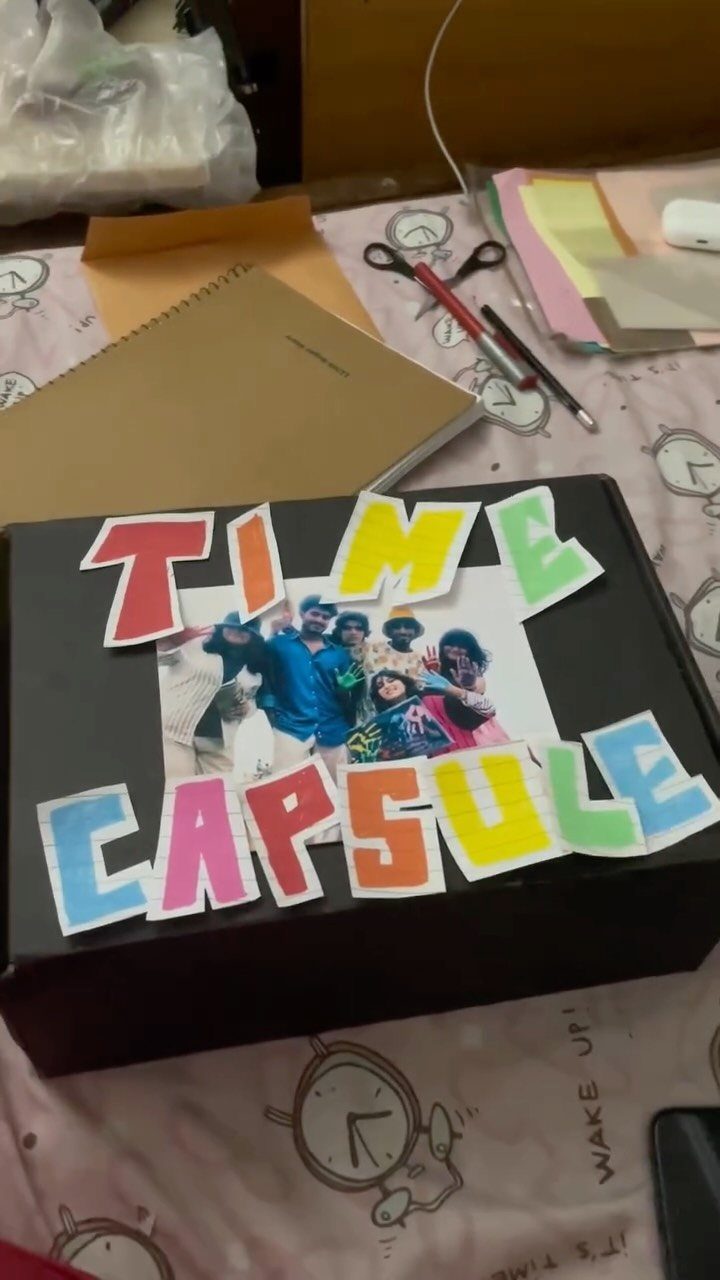 Black time capsule box decorated with a family photo and colorful cutout letters.