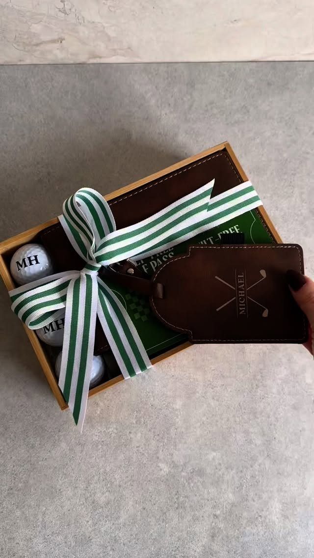 Personalized brown leather golf scorecard holder and golf balls in a gift box.