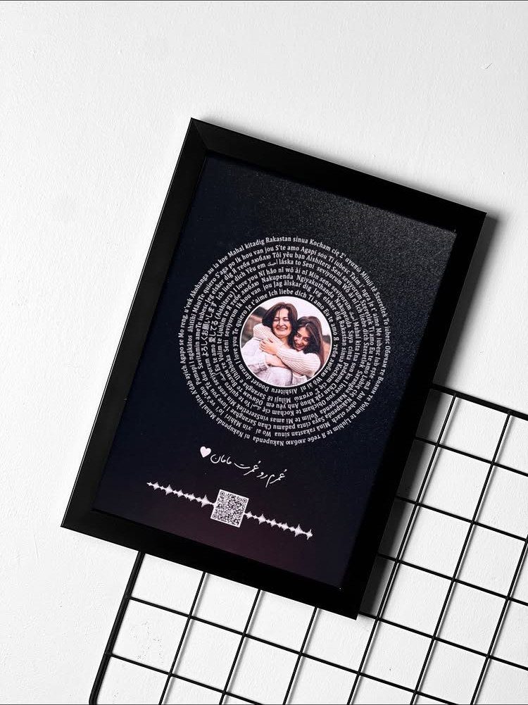 Black picture frame with a circular photo of two women surrounded by text