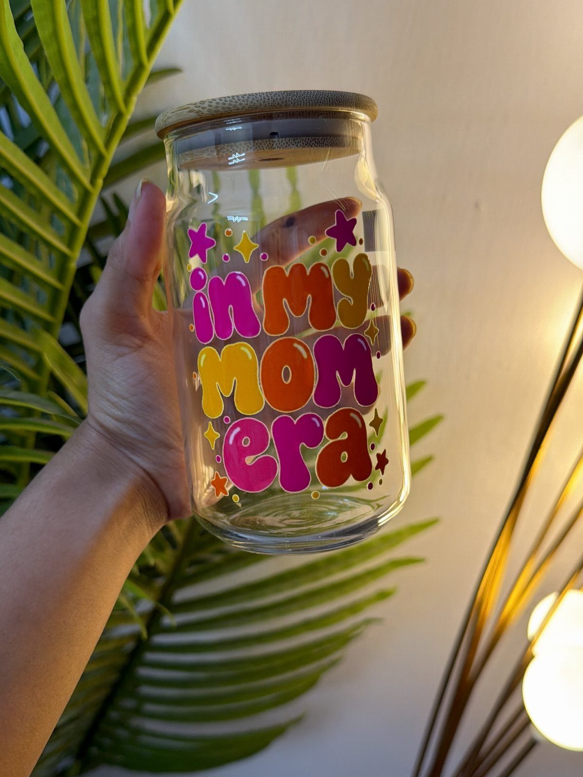 Glass jar with wooden lid featuring colorful 'in my mom era' text.