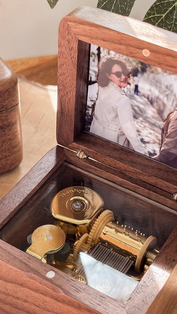 Wooden music box with a personal photo on the lid and gold gears.