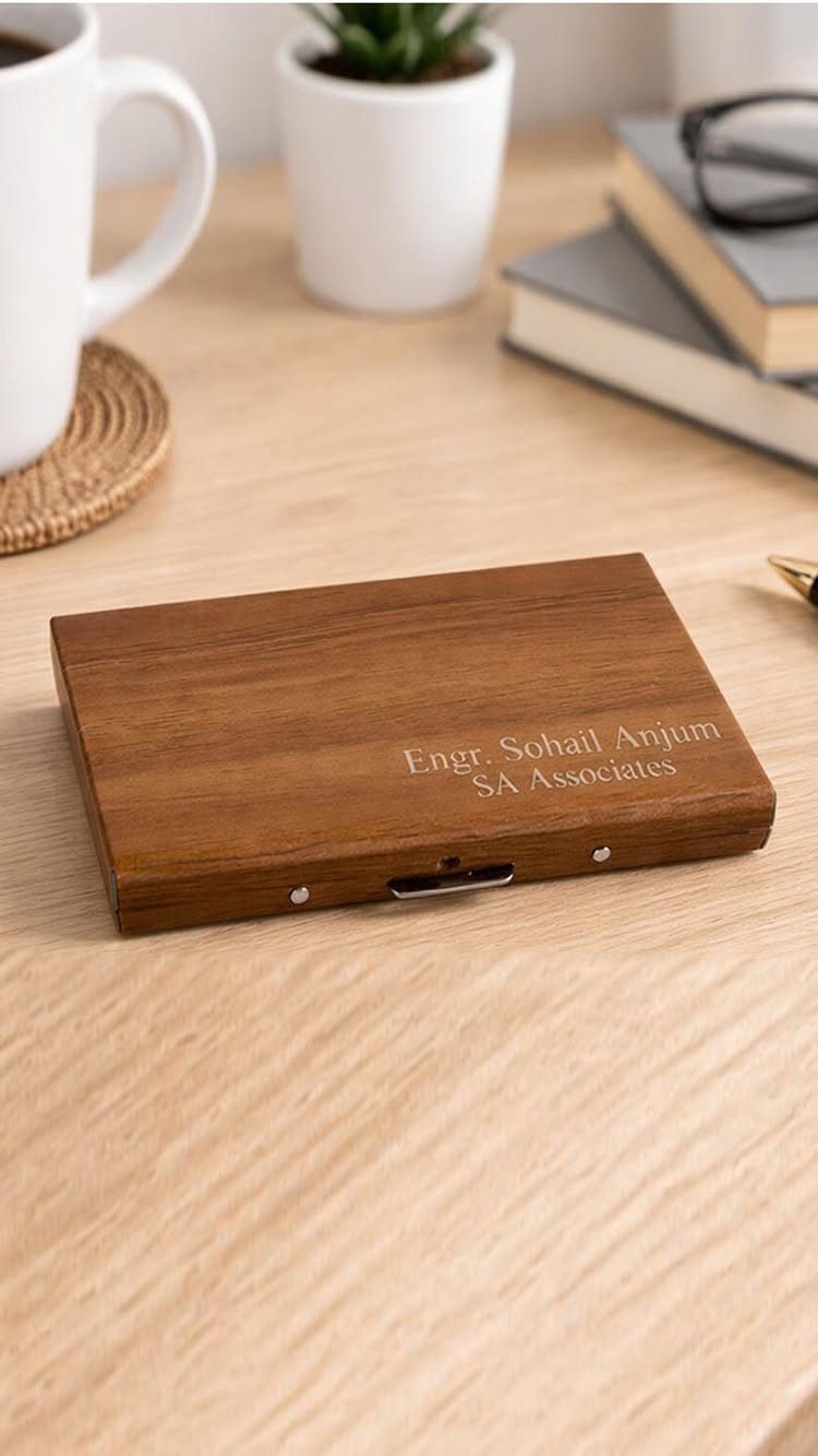 Engraved wooden box on a desk with a mug and books in background