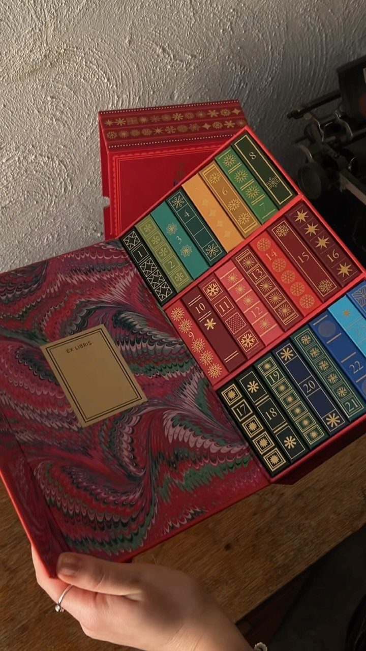 Red advent calendar box shaped like a bookshelf with numbered colorful miniature books.