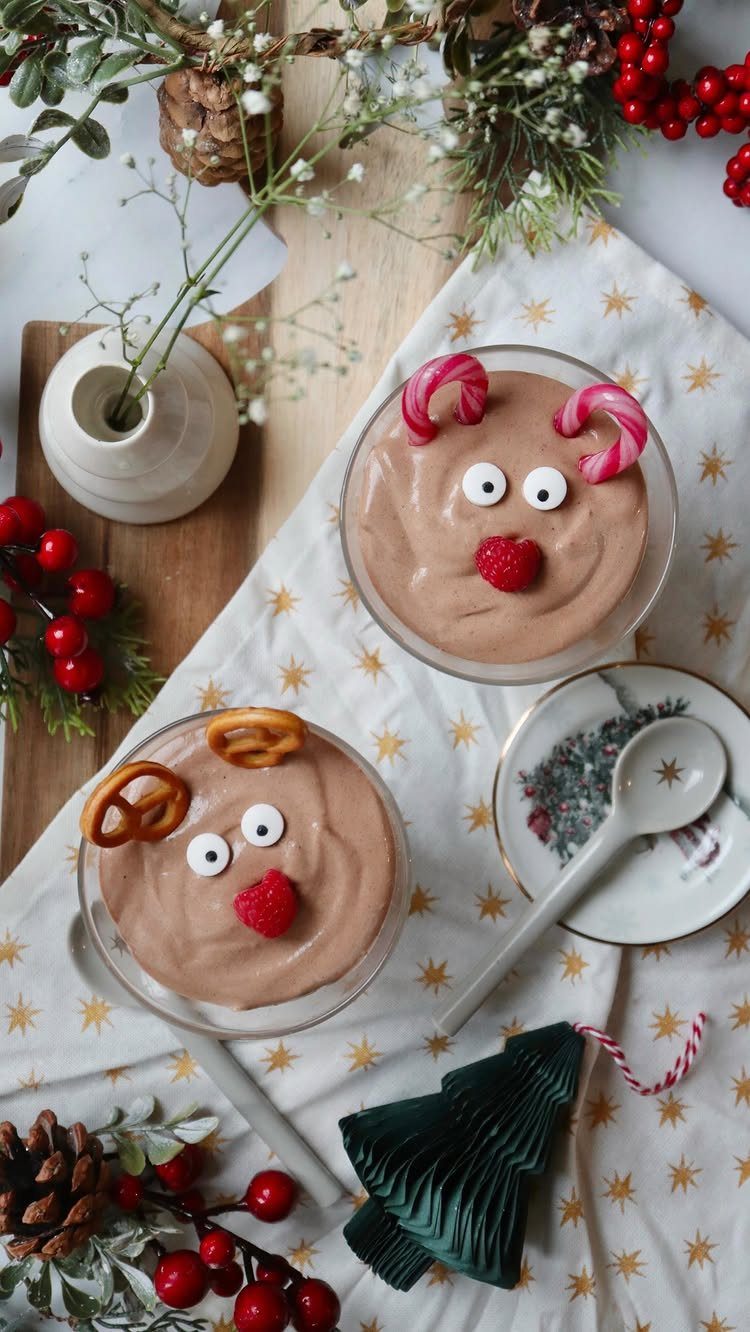 Chocolate mousse reindeer desserts with candy cane antlers and raspberry noses on festive cloth