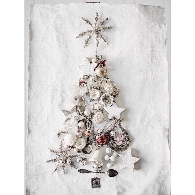 Christmas tree collage made from white and silver ornaments on white fabric