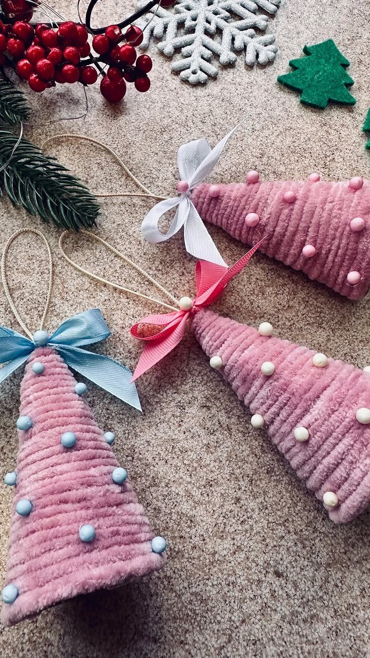 Pink yarn-wrapped Christmas tree ornaments with colorful ribbons and small bead accents.