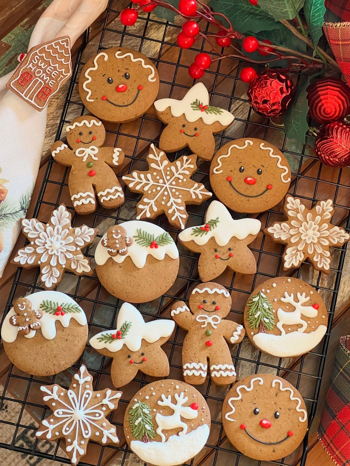 Gingerbread cookies in various festive shapes decorated with white icing on a cooling rack.