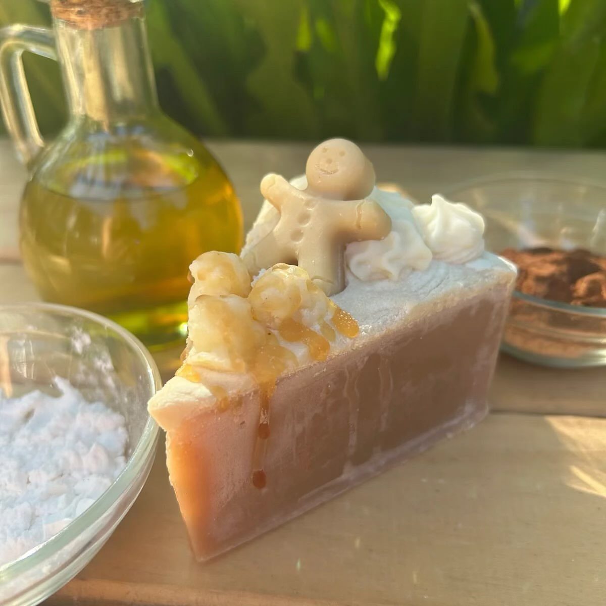 Cake-shaped artisanal soap topped with a gingerbread man and white frosting swirls.