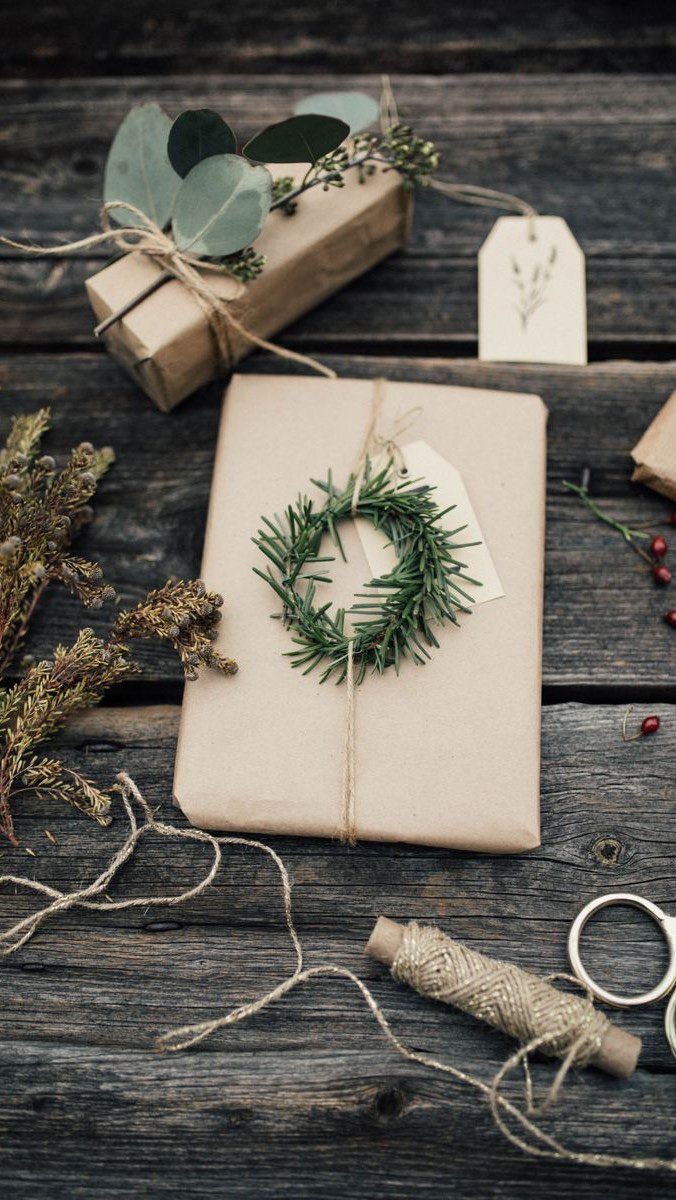 Brown kraft paper wrapped gifts tied with twine on a rustic wooden table