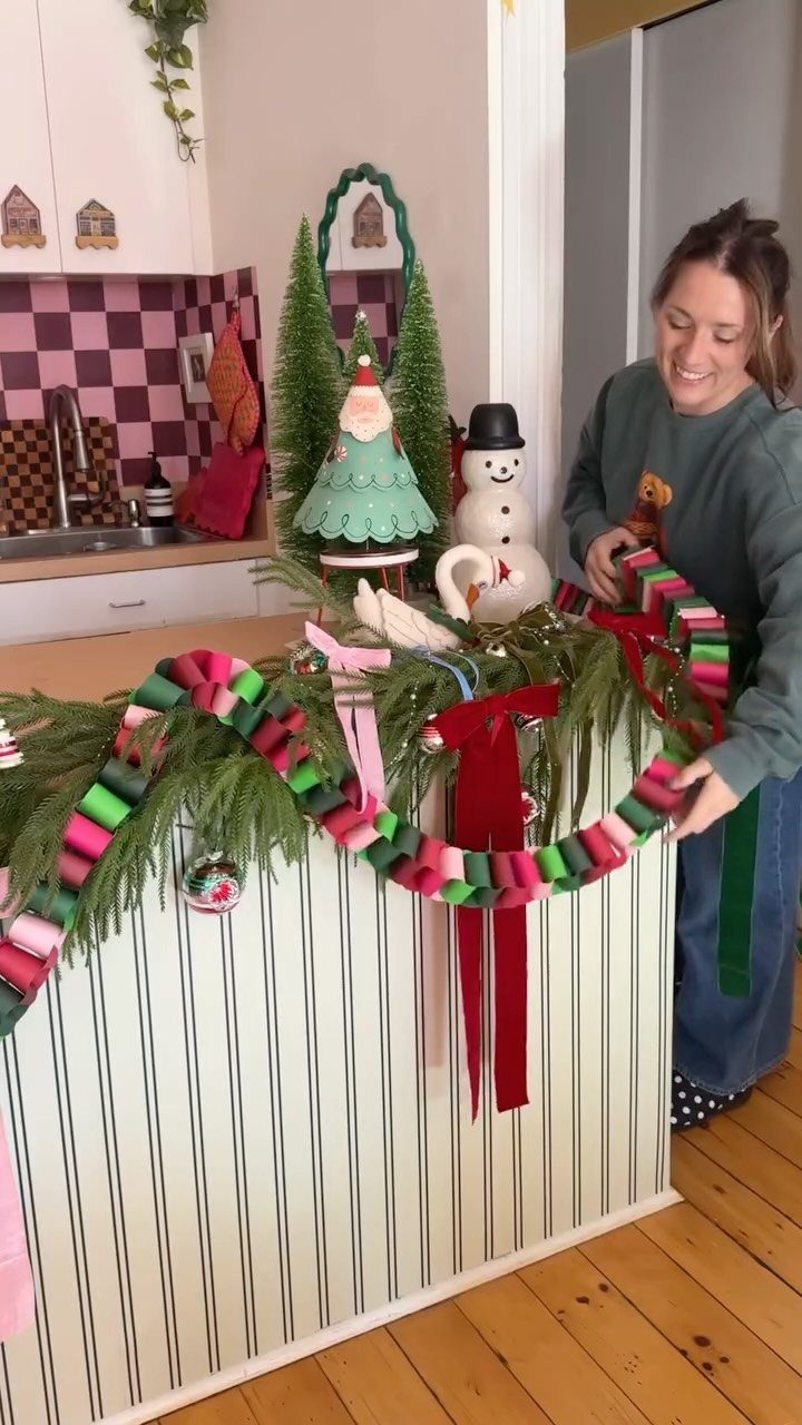 Woman arranging a pink and green paper chain garland on a festive counter