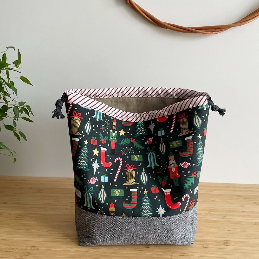 Christmas themed fabric storage bin with festive prints and a grey base.
