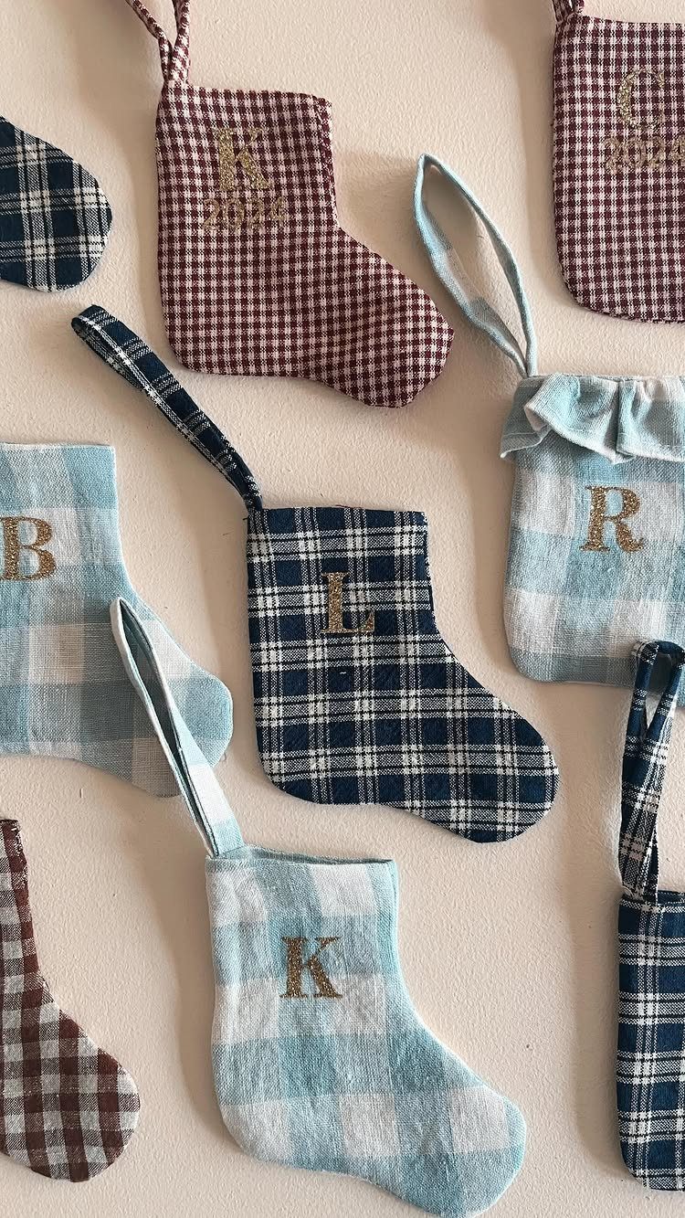 Small plaid fabric stockings with gold embroidered initials and hanging loops.