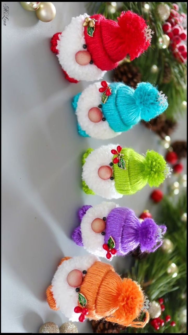 Five colorful handmade Christmas gnomes with knitted hats and fuzzy white beards.