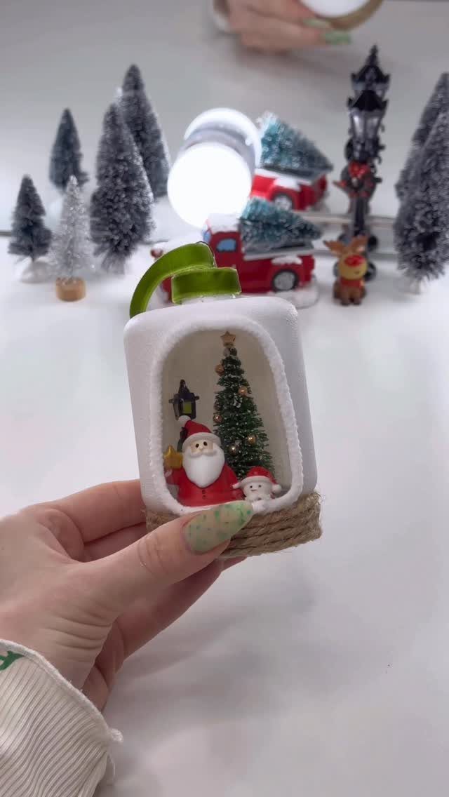 Miniature Christmas scene with Santa and a tree inside a white arch.