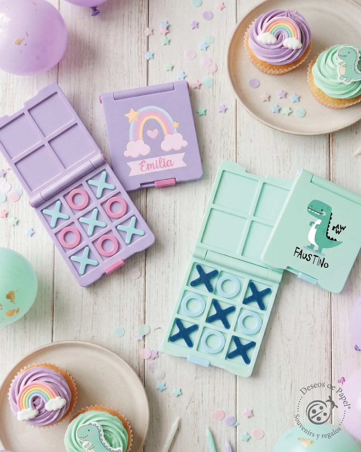 Two colorful tic-tac-toe game sets with cupcakes and confetti on a white table.